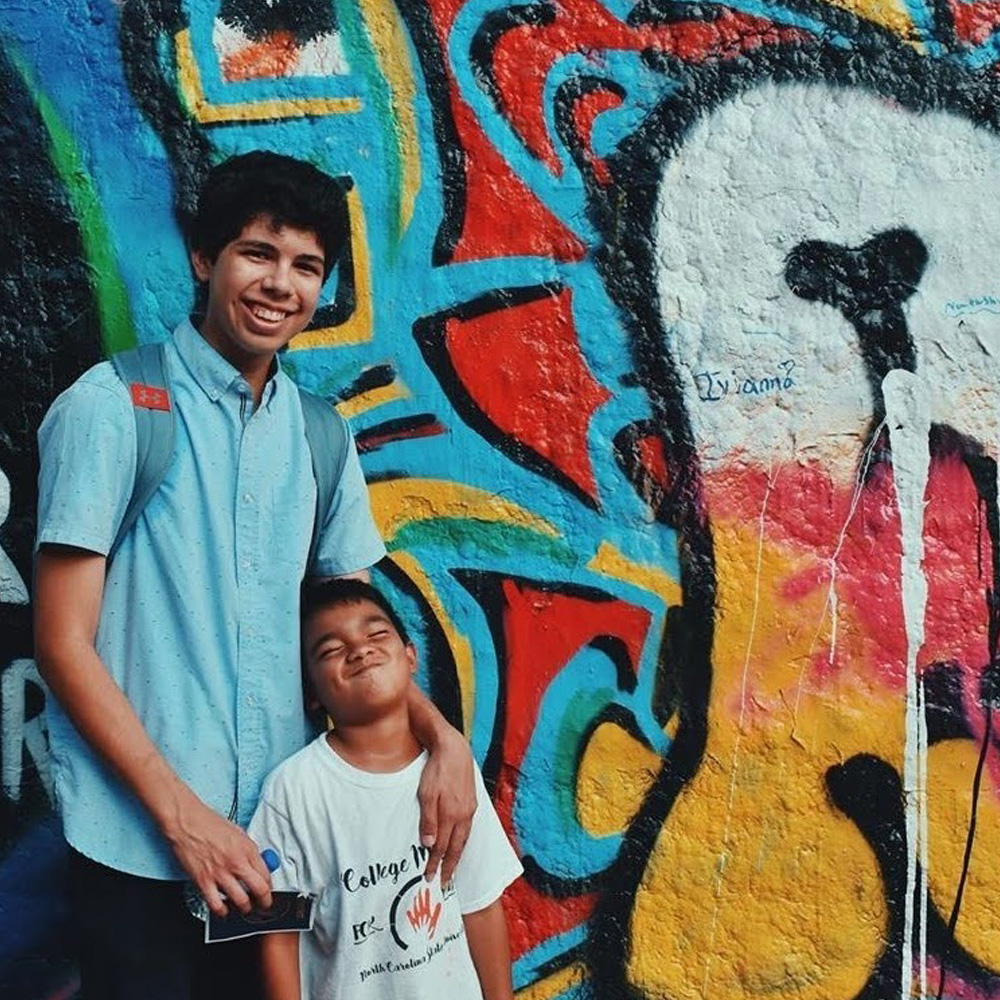 mentor with mentee infront of a painted wall