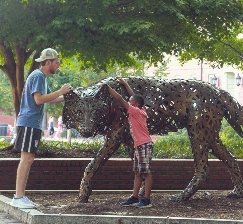 mentor and mentee at a wolf statue